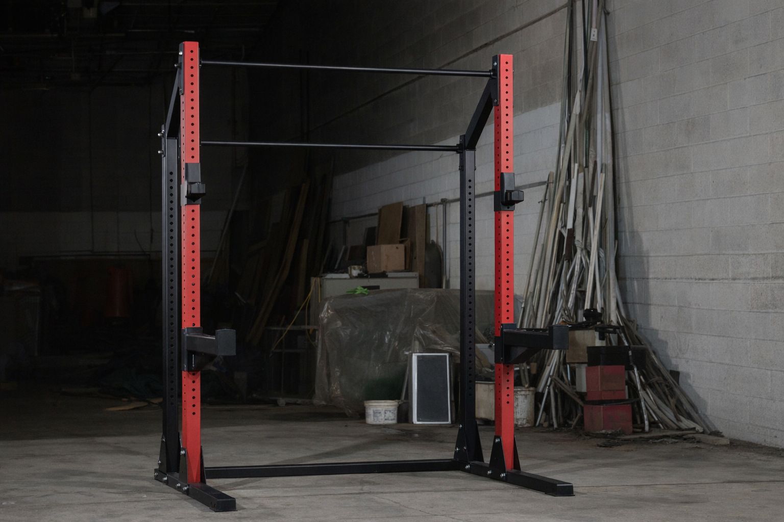 En robust röd och svart squat rack från Gorilla Sports i en industriell miljö.